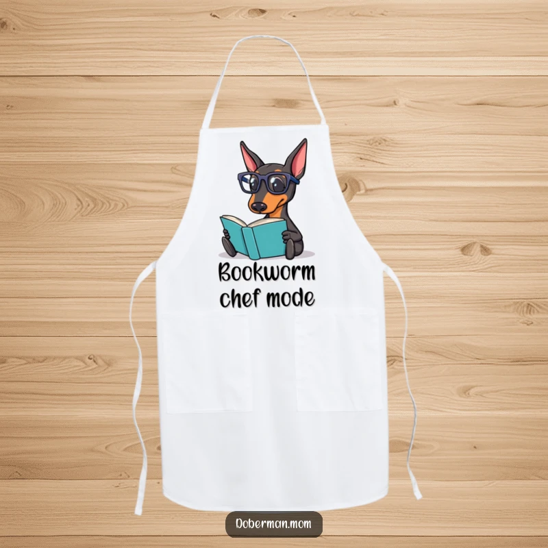 Funny Doberman Apron illustrating a Doberman dog in reading glasses, happily reading a book while imagining gourmet recipes.