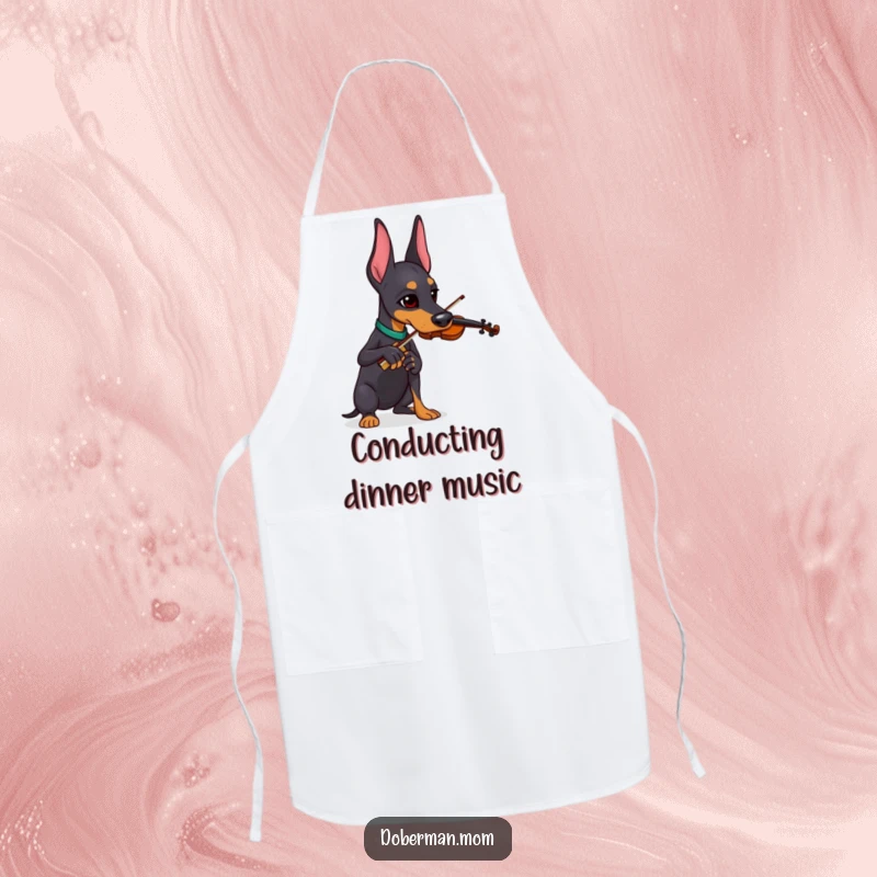 Funny Doberman wearing an apron and seriously playing a tiny violin while cooking, a funny kitchen gift.