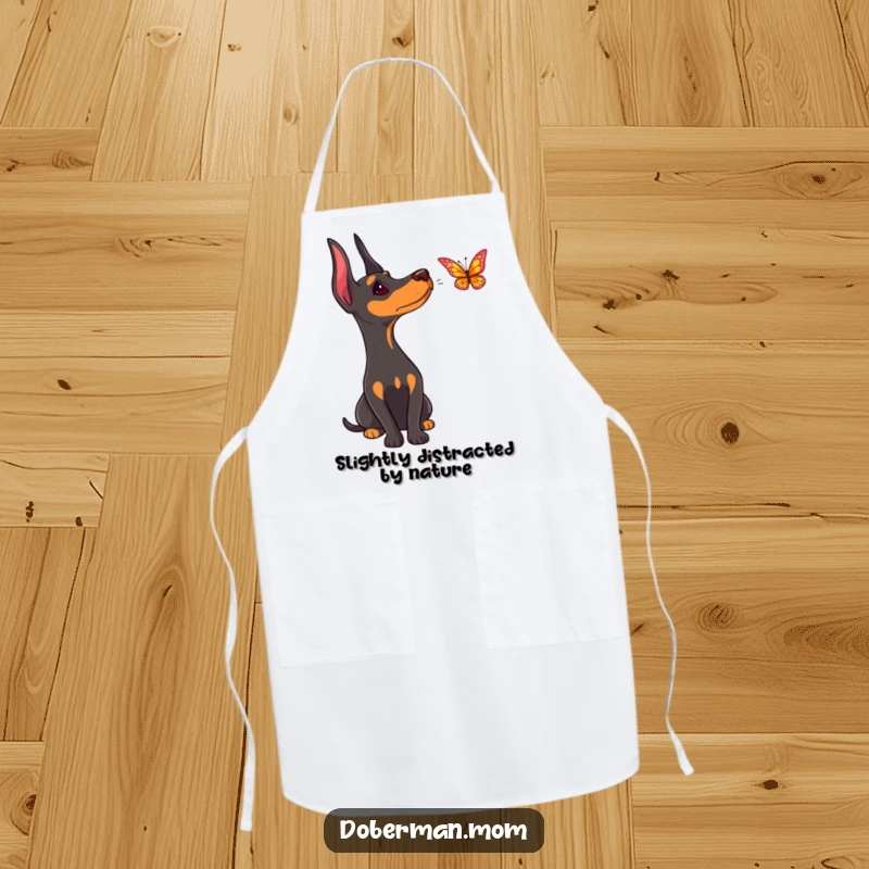 Funny Doberman apron, a dog curiously observing a butterfly while the cook prepares a meal in the kitchen.