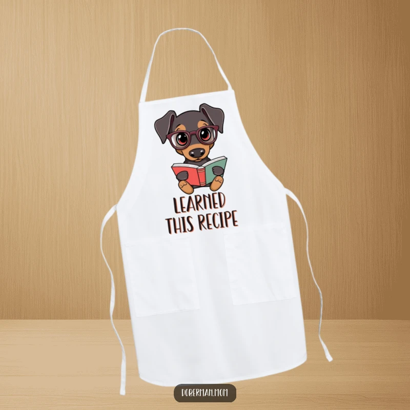 Funny Doberman Chef Apron: A Doberman dog wearing reading glasses looks ready to cook while holding a book.
