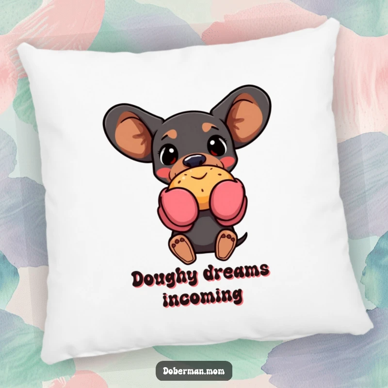Funny Doberman dog in oven mitts, holding a pastry, featured on a soft pillow, bringing cozy baking humor indoors.