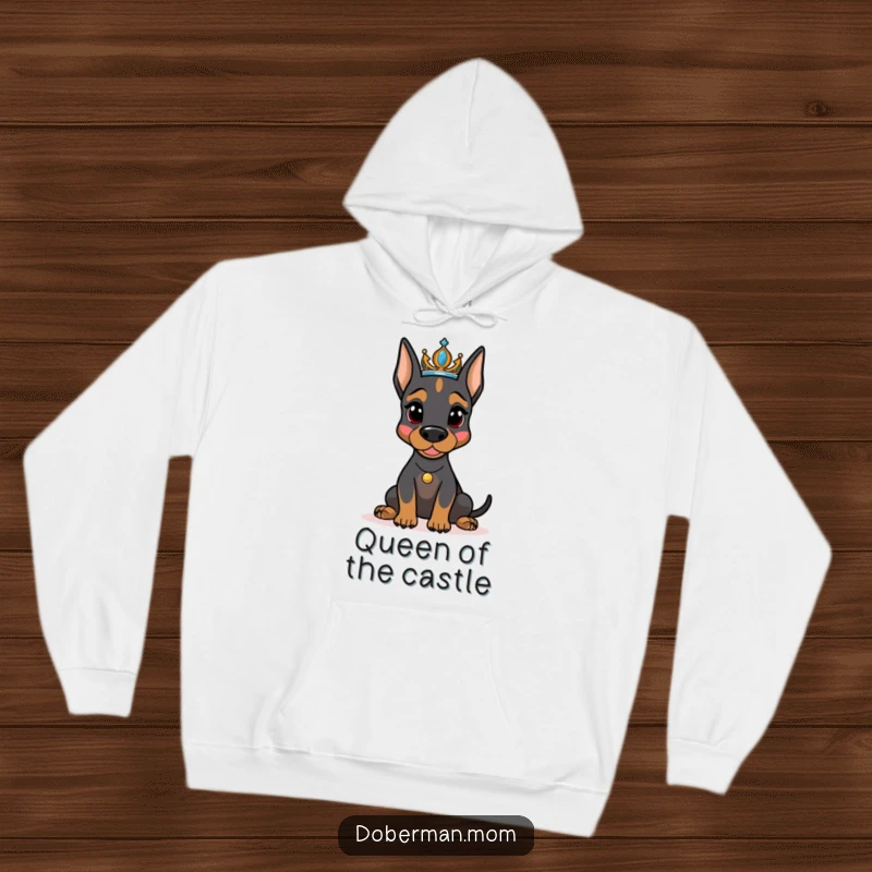 Funny Doberman dog with a sparkling tiara, looking regal and cozy on a warm hoodie, ideal for humorous dog enthusiasts.