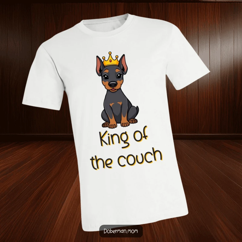 Funny Doberman dog wearing a tiny crown, sitting attentively on a t-shirt, representing loyal and humorous canine royalty.