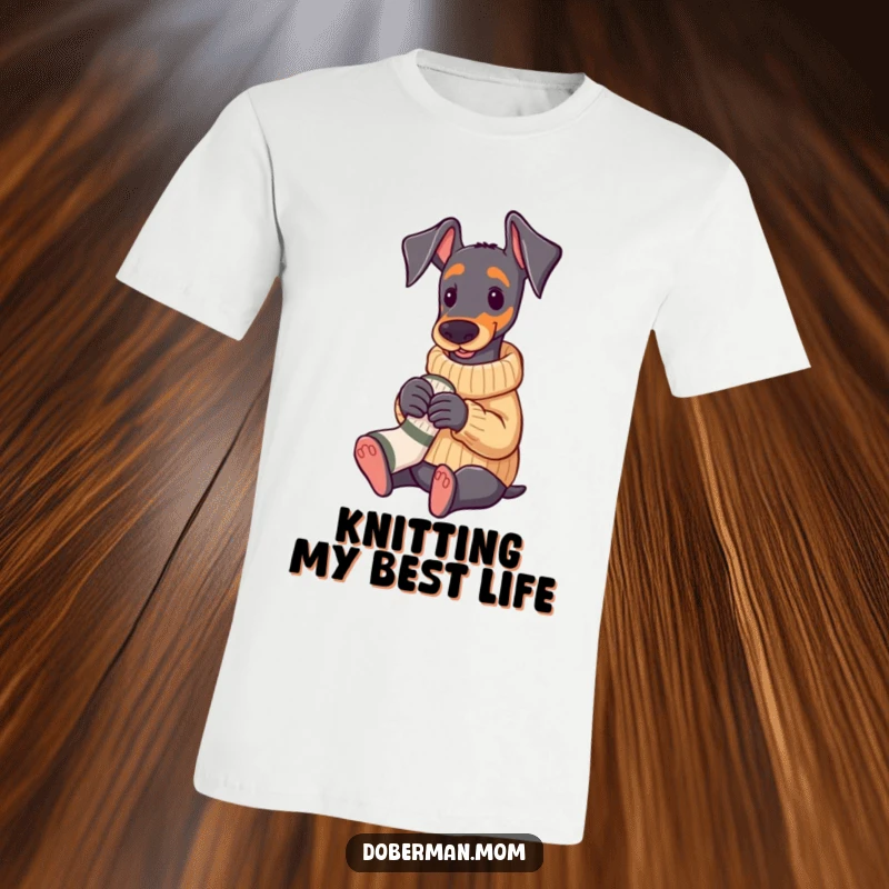 Funny Doberman dog wearing a cozy sweater, knitting a small sock, cute and humorous t-shirt.