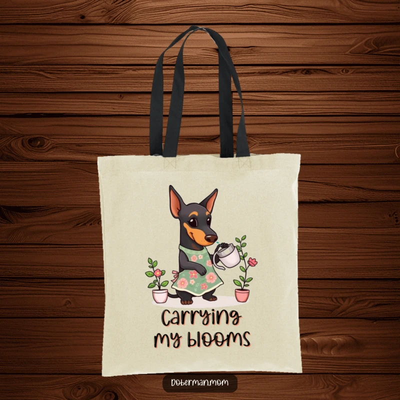 Funny Doberman Gardener Tote Bag with a Doberman dog wearing a floral apron, happily watering a small plant.