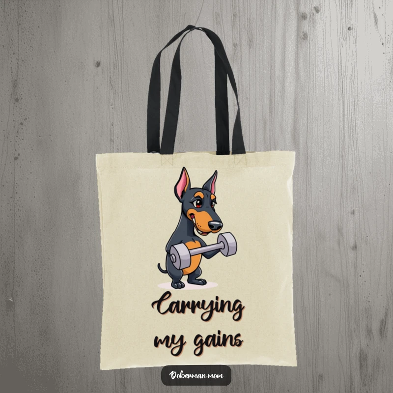 Funny Doberman tote bag with a tenacious dog balancing a mini dumbbell, showcasing strength and humor.